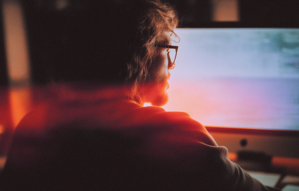 Professional wearing glasses focused on computer screen looking a-little puzzled and confused